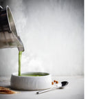 Heiße Suppe wird aus dem Vitamix 1,4 L Edelstahl-Behälter in eine Schale gegossen