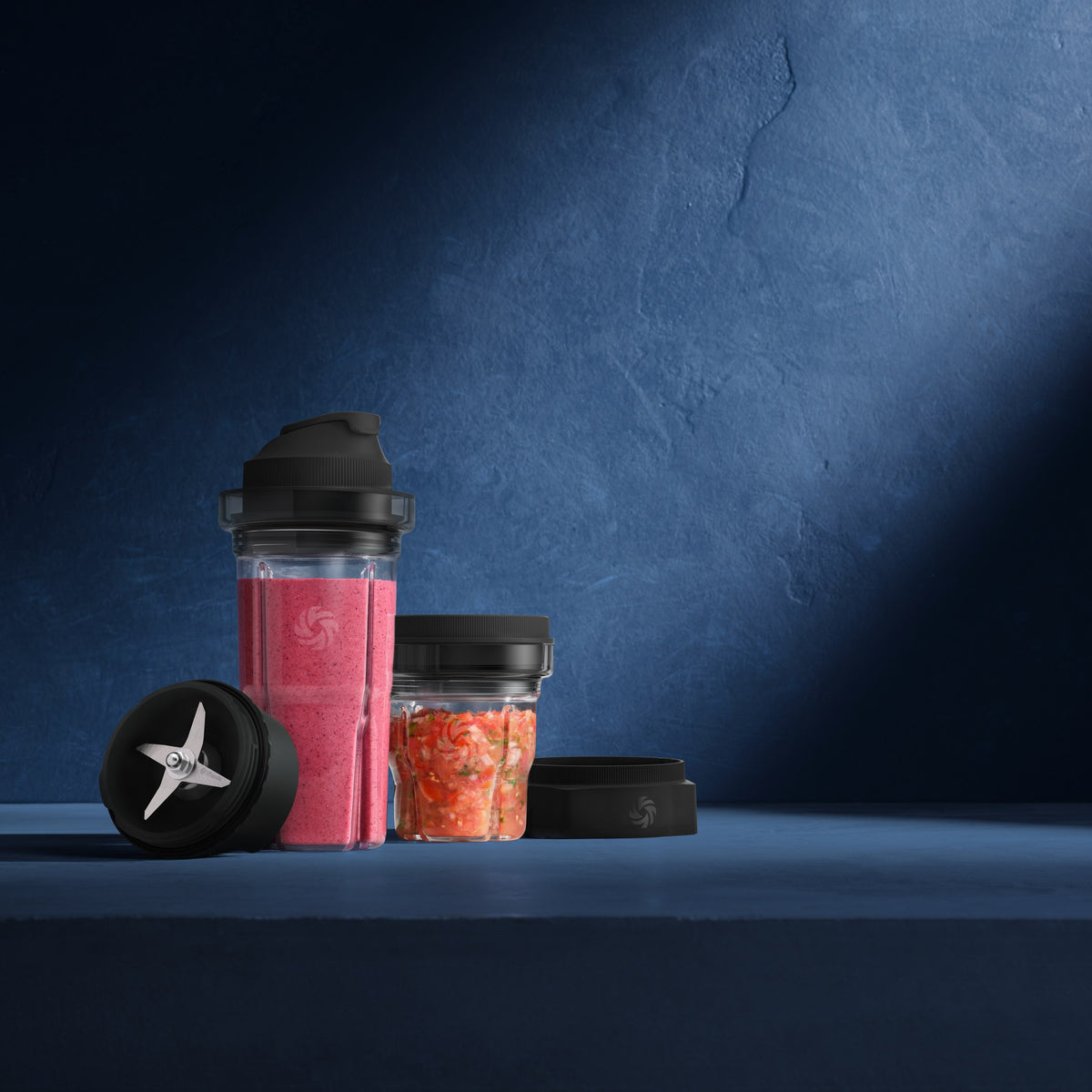 Vitamix Blending-Cup mit Erdbeersmoothie und Blending-Bowl mit Dip, daneben Messerbasis und Adapter