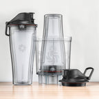 Vitamix Personal Cup Adapter Set auf Holzarbeitsflaeche: 2 To-Go Cups 600 ml, Adapter und 2 Flip-Top-Deckel