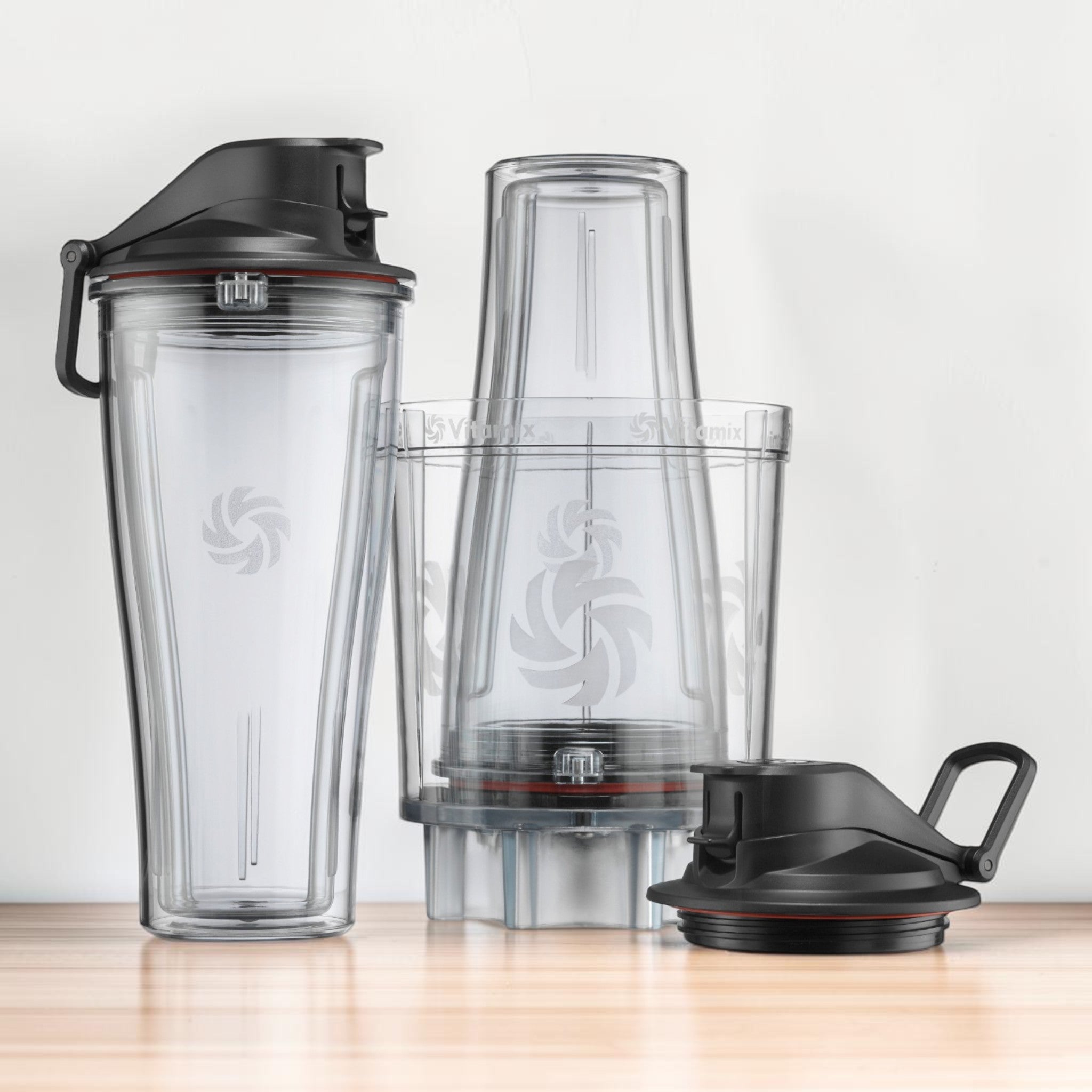 Vitamix Personal Cup Adapter Set auf Holzarbeitsflaeche: 2 To-Go Cups 600 ml, Adapter und 2 Flip-Top-Deckel