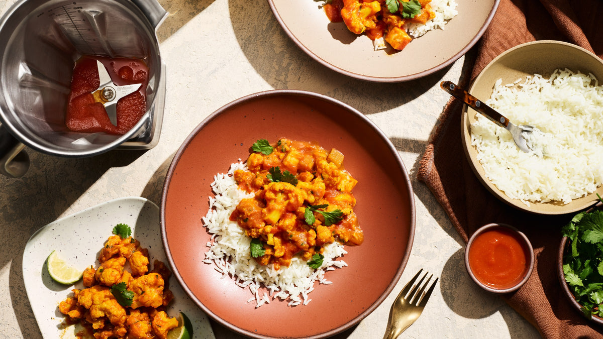 Gedeckter Tisch mit Curry und Reis, daneben der Vitamix Edelstahl-Behaelter